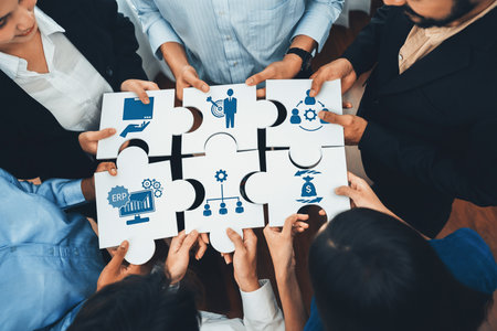 A diverse group of professionals collaborate over puzzle pieces featuring icons representing ERP,...