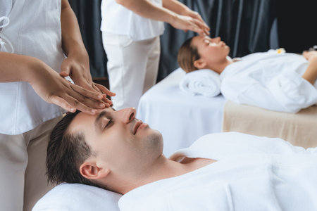 Caucasian couple enjoying relaxing anti-stress head massage and pampering facial beauty skin...