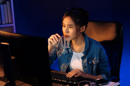 Stressful young beautiful asian creative looking on pc to search project creator social media online...