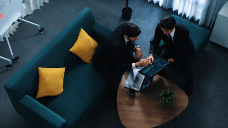 Top view of business people analyze stock market investment data by using laptop and financial graph while project manager walk out of the meeting room. Creative business. Directorate.の写真素材