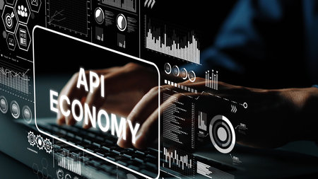 Digital Concept of API Economy with Hands Typing on Keyboard Surrounded by Data Visualizations and...