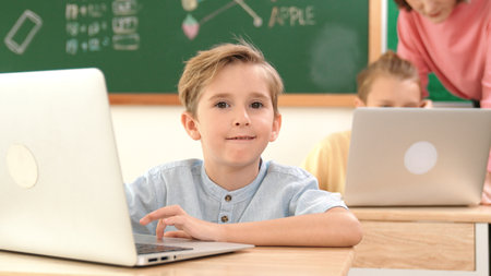 Attractive caucasian boy looking at camera while studying math at school. Diverse cute student doing...