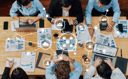 A diverse business team engages in collaborative discussion at a wooden table, surrounded by digital...
