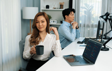 Profile smiling beautiful Asian businesswoman looking camera while holding cup to pose at modern...