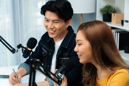 Smiling radio influencer hosts with channel social media online live streaming with talking topic...