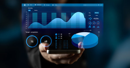 A person holds a smartphone displaying a business analytics dashboard featuring graphs and charts....