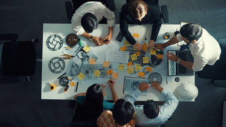 Time lapse of smart engineer team in casual cloth talking about turbine engine structure at table with metal gear, calculator, sticky notes. Group of technician taking a note in meeting.の写真素材