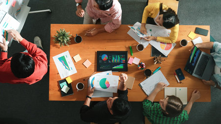 Top view of skilled businessman present marketing idea at meeting while group of investor listening and planning strategy while looking at stock market chart or data analysis document. Convocation.の写真素材