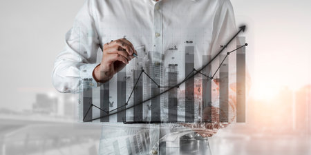 A business professional illustrates a rising financial growth graph overlaying a cityscape, symbolizing success and strategic planning in modern finance. Imputeの写真素材