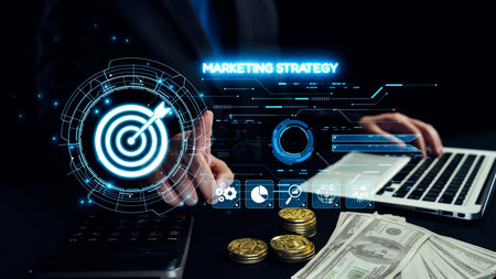 A business professional interacts with a futuristic digital marketing strategy interface displayed above a laptop, surrounded by coins and dollar bills, illustrating modern finance trends. Qubitの写真素材