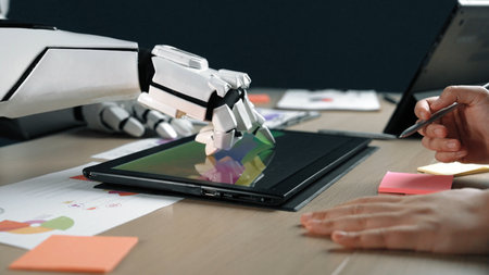 A futuristic robot hand interacts with a digital tablet on a sleek modern workspace, surrounded by colorful sticky notes and design documents, highlighting innovation and technology.Noogenesisの写真素材