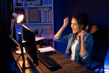 Host channel Asian influencer talking in broadcast streaming online wearing headsets on social media with pc recording, greeting listeners and coaching market online at neon modern studio. Stratagem.の写真素材