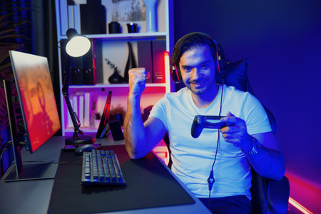 Smart gaming streamer with joystick player looking at camera, playing battle team shooting gun background at warship on pc screen at side view, wearing headset at digital neon light studio. Surmise.の写真素材