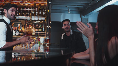 Feeling good smell tasty serving special drink to VIP customer with couple in classical mixing whiskey liquor cocktail by smart bartender opening at beverage counter bar luxury.の写真素材