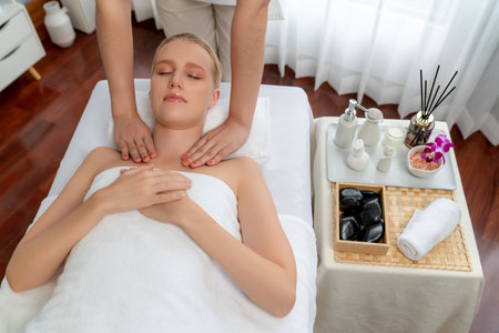 Caucasian woman customer enjoying relaxing anti-stress spa massage and pampering with beauty skin recreation leisure in day light ambient salon spa at luxury resort or hotel. Quiescentの写真素材