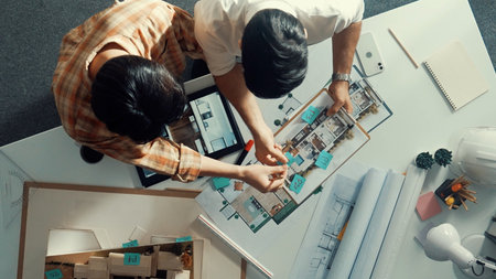 Top down view of skilled businessman and colleague designing a house together. Aerial view of...