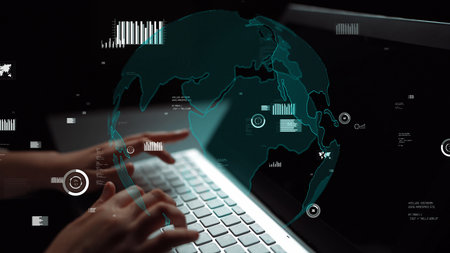 Close-up of hands typing on a laptop keyboard with an overlay of a globe and data visualizations,...