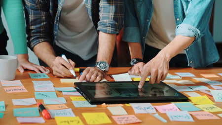 Skilled business team looking at laptop and pointing logo design while making decision to choosing...