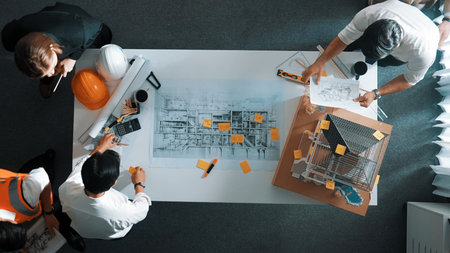 Top down view of skilled engineer team talking about house construction. Aerial view of group of...