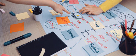 A vibrant workspace where a team actively collaborates on a flowchart using colorful sticky notes...