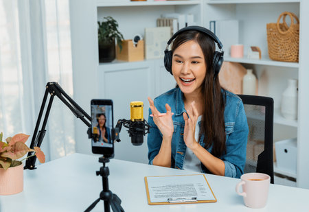Host channel Asian influencer talking in broadcast wearing headsets on social media live on...