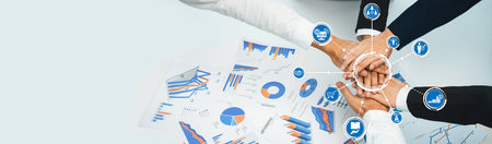 A diverse group of professionals collaborates over financial reports, showcasing graphs and charts,...
