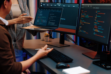 Series of IT developers discussing intelligent website development with two screens and a laptop...