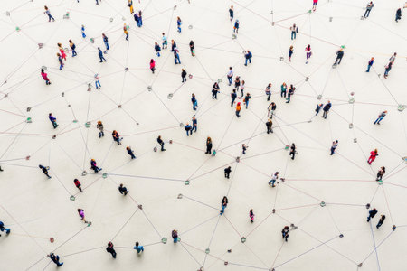This aerial view captures a vibrant crowd engaging in various activities on a uniquely patterned ground, showcasing connections and interaction in an urban setting.の素材