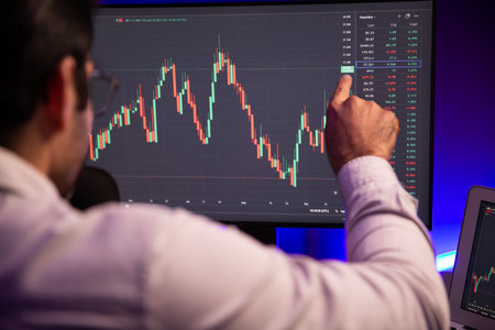 Smart trader businessman concentrating on dynamic stock exchange investment on pc and laptop showing...