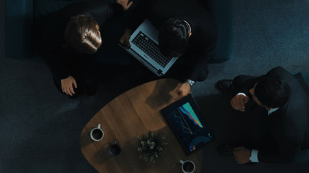 Top down aerial view of skilled businesswoman joining a business meeting while diverse team analyze financial data by using tablet and laptop. Investor explain financial plan with group. Directorate.の写真素材