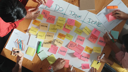 Top view of people writing and making scrum task board while writing marketing and planning strategy...