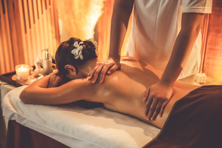 Caucasian woman customer enjoying relaxing anti-stress spa massage and pampering with beauty skin recreation leisure in warm candle lighting ambient salon spa at luxury resort or hotel. Quiescentの写真素材