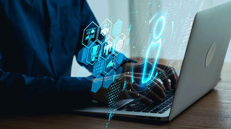 Modern technology interface concept with person working on laptop, digital icons, and holographic...