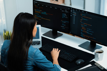 Young Asian IT developer typing online information on pc with coding program data of website...