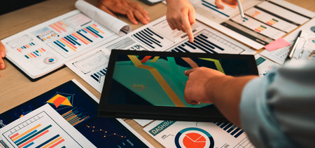 A diverse team collaborates in a modern office, engaging in data analysis. They use a digital tablet...