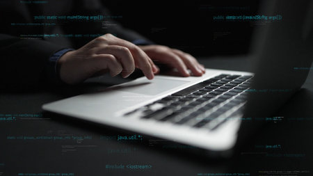A close-up image featuring professional hands skillfully typing on a laptop keyboard, with code in...