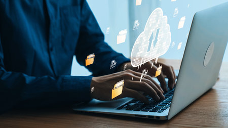 Hands typing on a laptop with cloud storage concept and digital icons representing data transfer and...