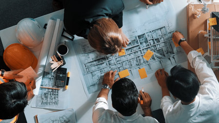 Top down view of skilled engineer team talking about house construction. Aerial view of group of architect or designer discussing and writing sticky note to brainstorm about blueprint.の写真素材