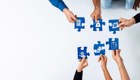 This image depicts hands collaborating over puzzle pieces symbolizing business solutions and...