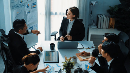 Top view of professional businesswoman pointing mind map and investment chart at whiteboard while...