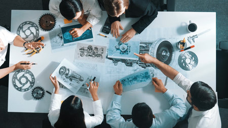 Top down view of skilled engineer showing and talking about turbine engine design. Aerial view of...