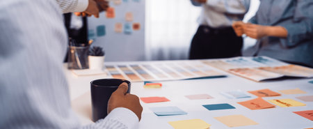 A diverse group of professionals engages in a lively brainstorming session, using colorful sticky...