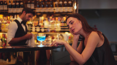 Sitting beautiful woman guest feeling bored waiting friends or couple with drinking mixed vodka in...