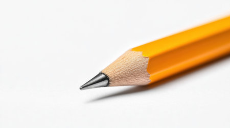 A close-up image of a sharpened yellow pencil showcasing its fine tip against a white background, perfect for educational or creative concepts.の素材