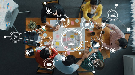 An overhead view of a business meeting showcasing a diverse team collaborating on analytics and...