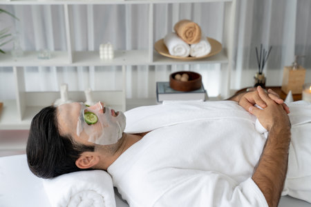 Serene daylight ambiance of spa salon, man customer indulges in rejuvenating with luxurious cucumber...