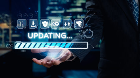 A businessman holds a digital interface displaying an updating progress bar, symbolizing technology and innovation in a modern office with a city backdrop at night.の写真素材