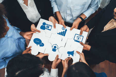This image captures a diverse team collaborating on a marketing strategy, holding puzzle pieces that symbolize important business concepts and data insights for growth.の写真素材