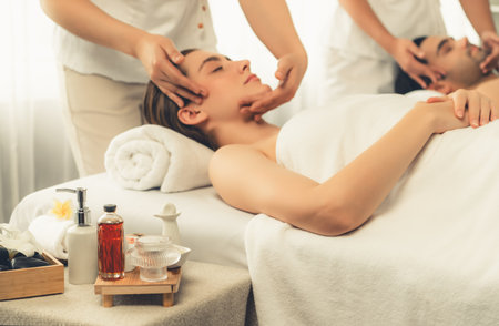 Caucasian couple enjoying relaxing anti-stress head massage and pampering facial beauty skin recreation leisure in dayspa modern light ambient at luxury resort or hotel spa salon. Quiescentの写真素材