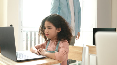 American girl learning about coding engineering prompt while diverse students sitting at STEM technology class. Multicultural children working on laptop to generated AI by using software. Pedagogy.の写真素材